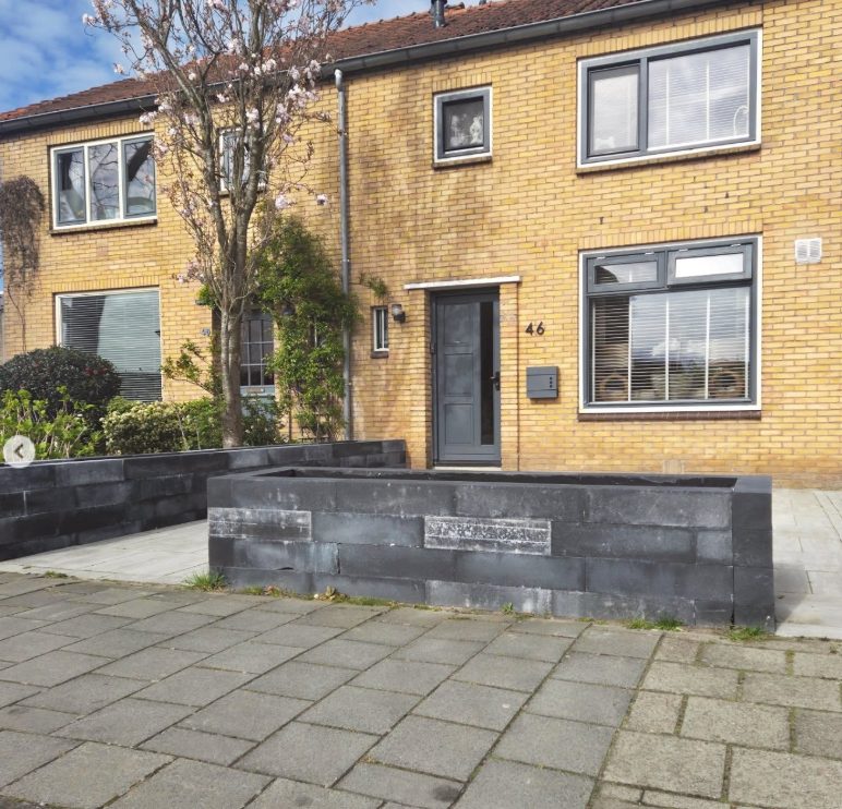Voor: plantenbakken van ruwe betonblokken in de voortuin