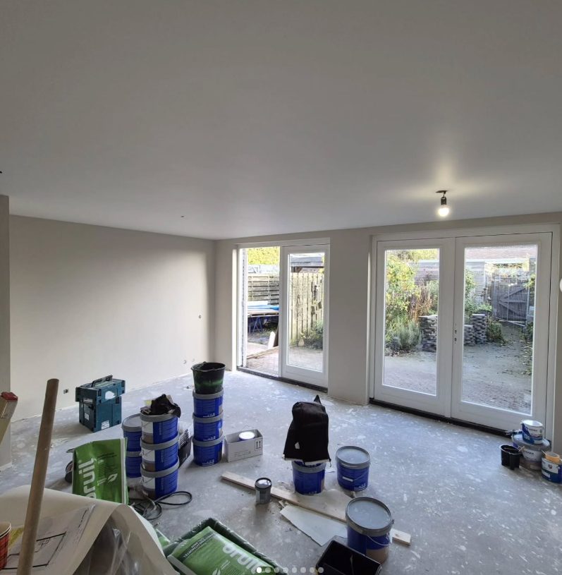Sausklaar gestuukte woonkamer met openslaande tuindeuren, strak opgeleverd door TAF Afbouw
