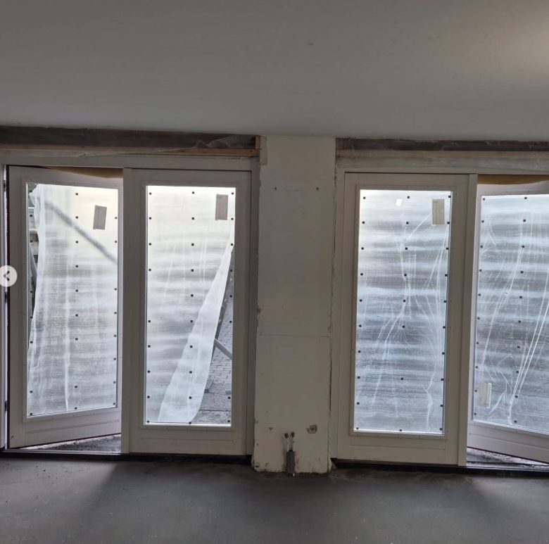 Voor: kale ruwbouw met onafgewerkte wanden en afgeplakte tuindeuren